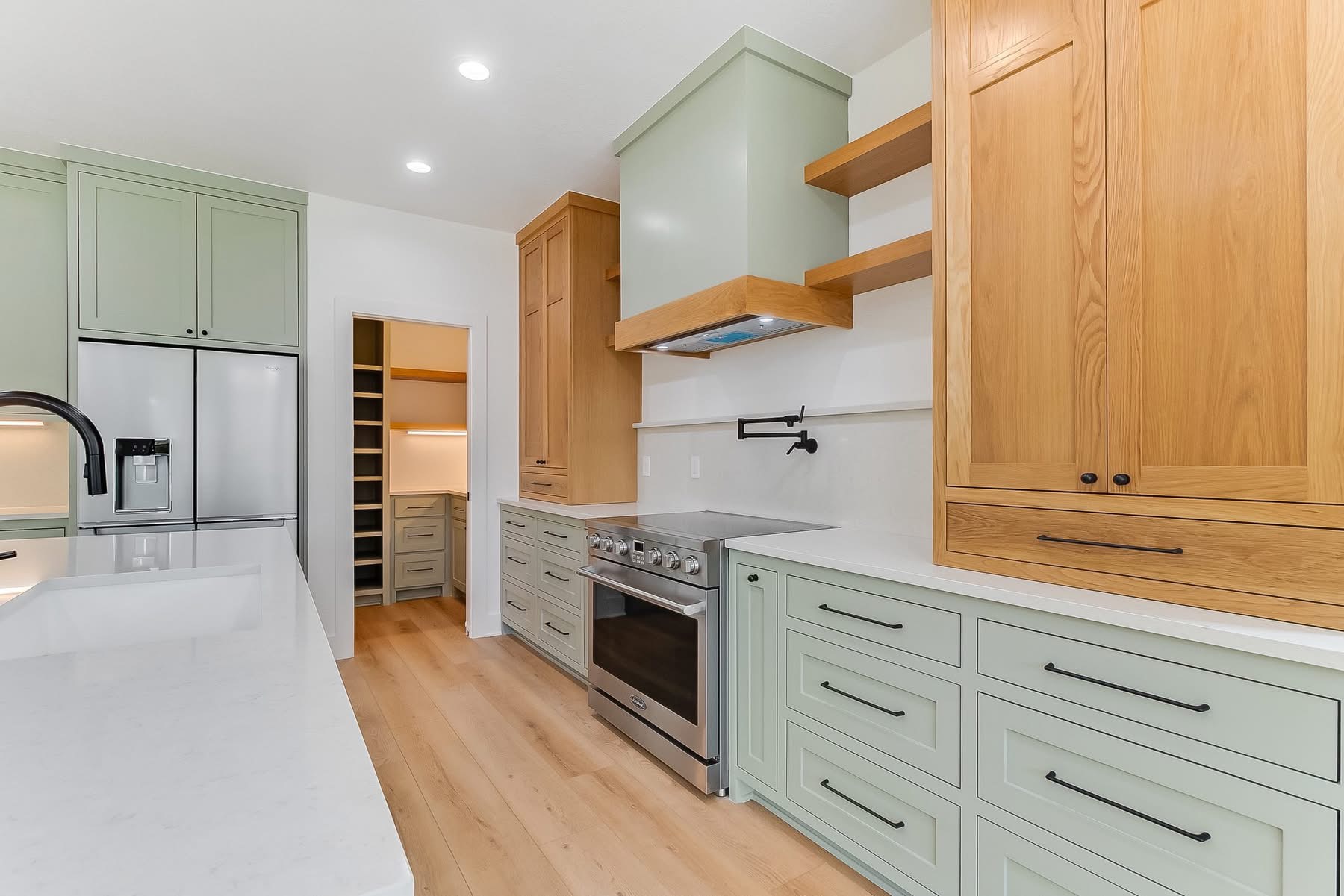 Sage green kitchen with brass fixtures