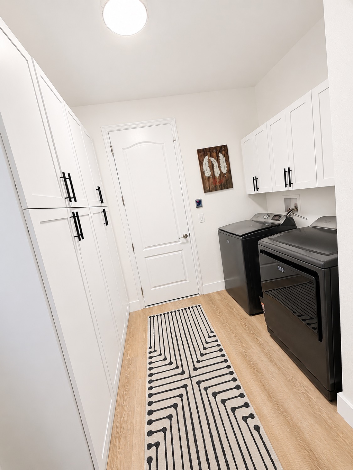 Remodeled laundry room with white cabinetry