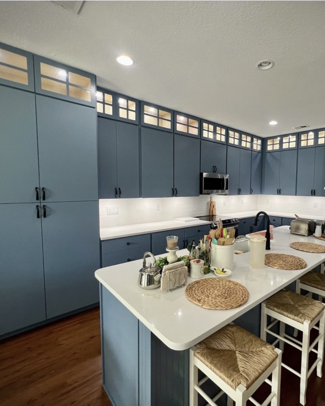 Navy blue kitchen island with seating and pendant lighting — St. Louis remodel by Phoenix Construction Group