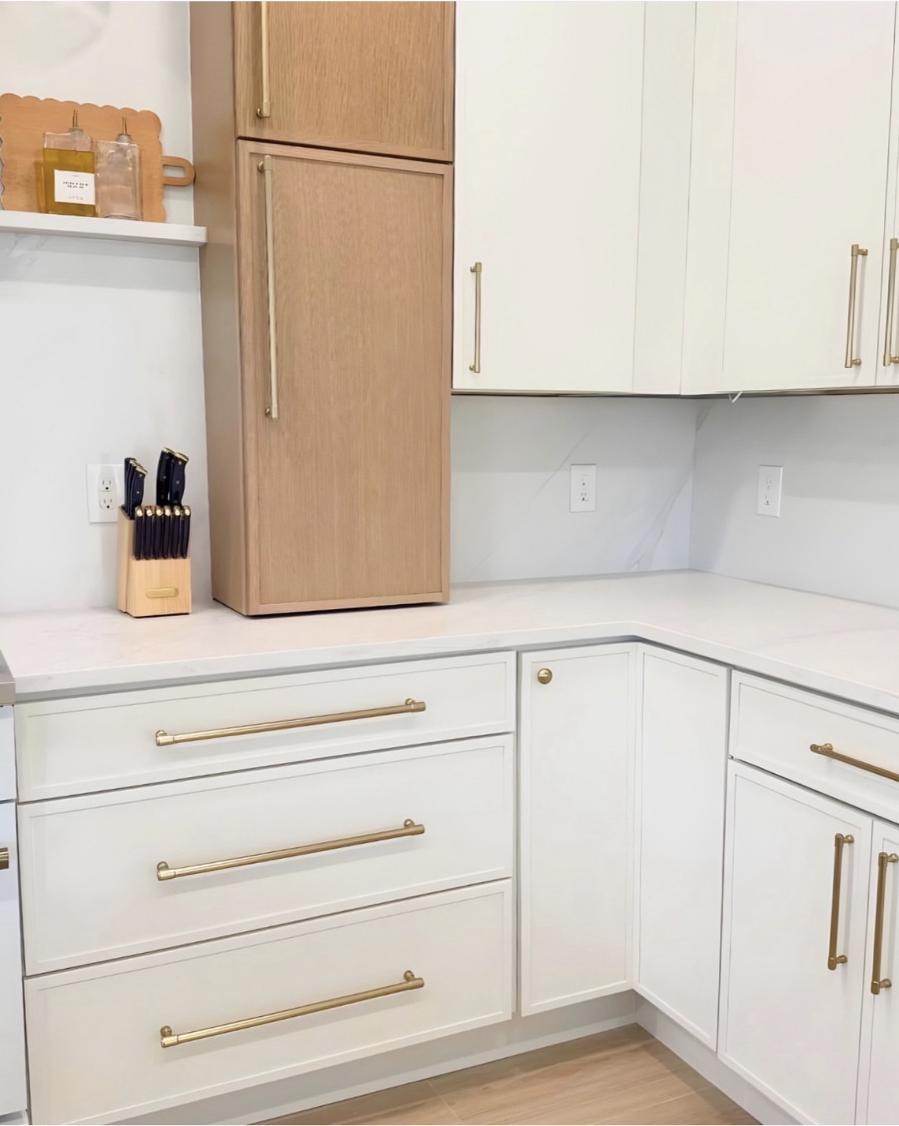White kitchen with natural wood accent cabinet and gold hardware — St. Louis remodel by Phoenix Construction Group