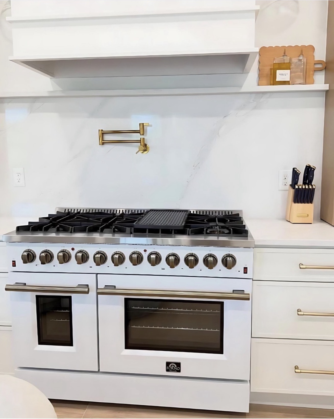 Elegant white kitchen with marble backsplash and gold pot filler — St. Louis remodel by Phoenix Construction Group