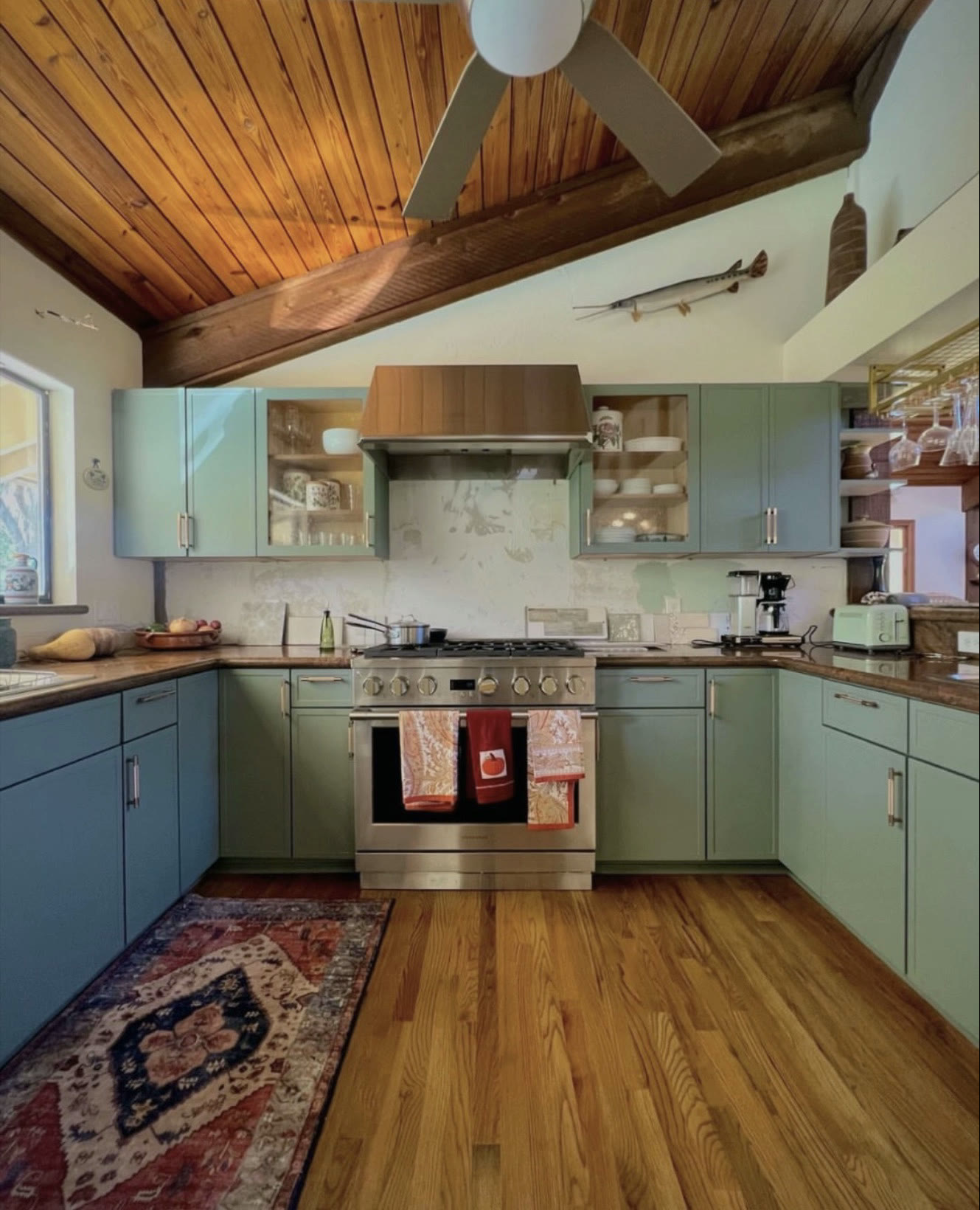 Sage green kitchen with wood-plank vaulted ceiling — St. Louis remodel by Phoenix Construction Group