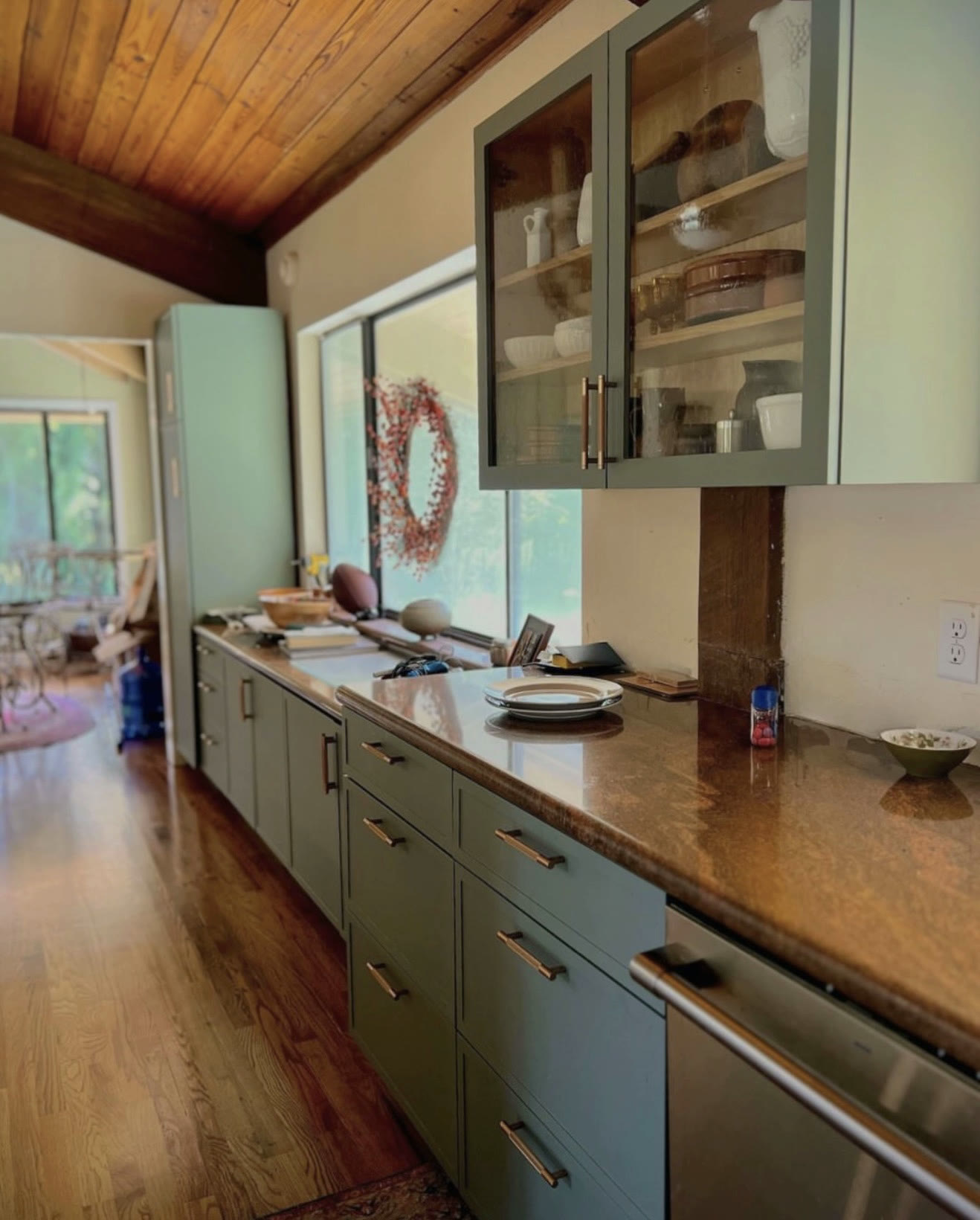 Warm green galley kitchen with open shelving — St. Louis remodel by Phoenix Construction Group