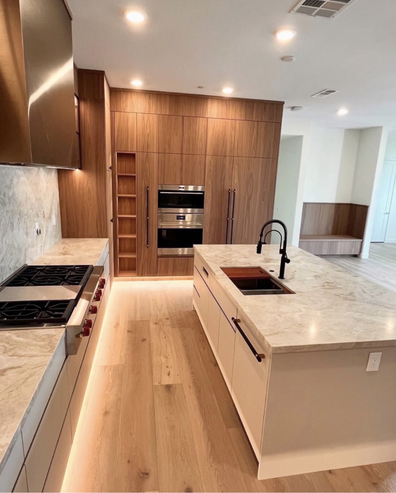 Modern walnut kitchen with waterfall island and wine display — St. Louis remodel by Phoenix Construction Group