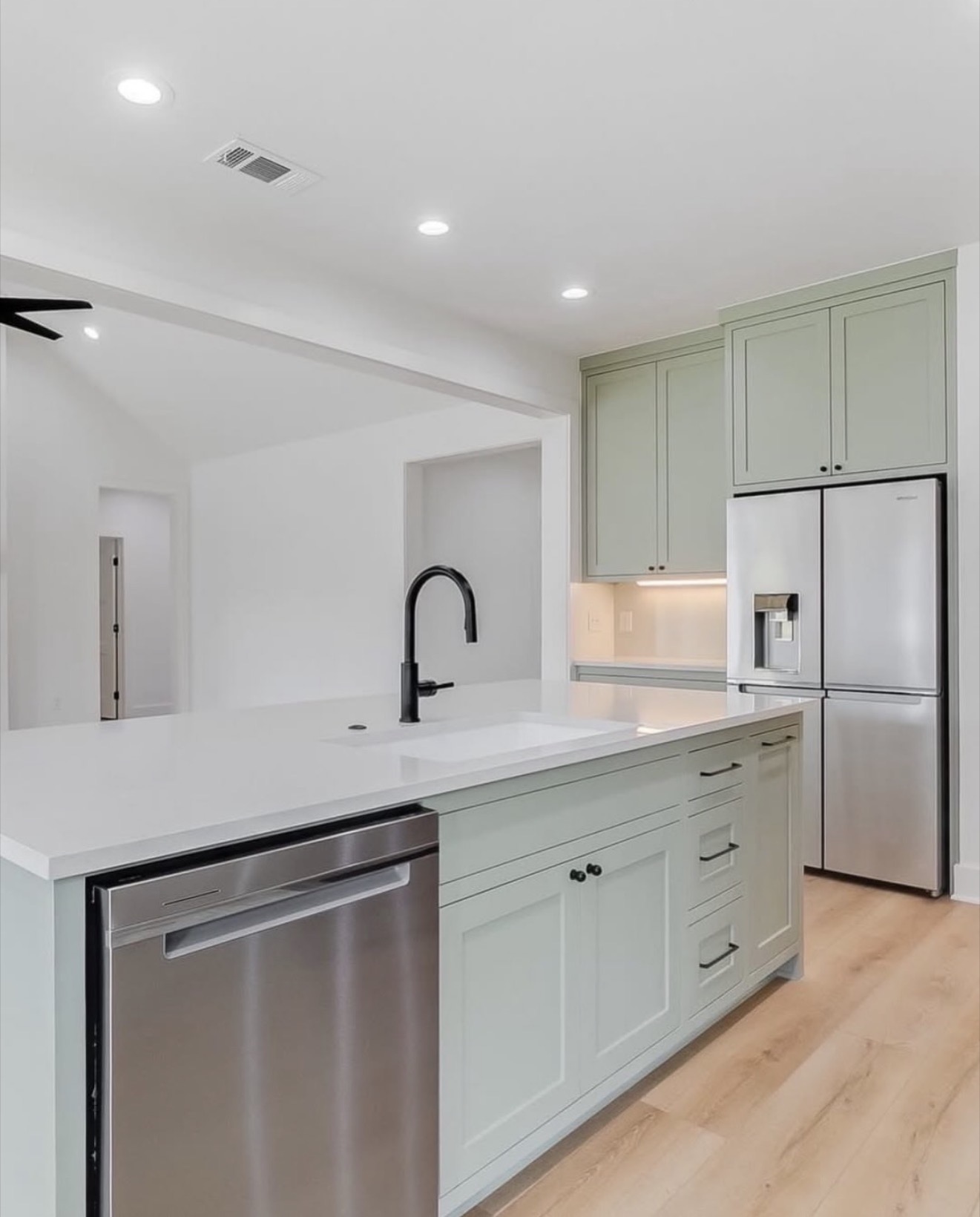 Bright sage green kitchen with center island — St. Louis remodel by Phoenix Construction Group