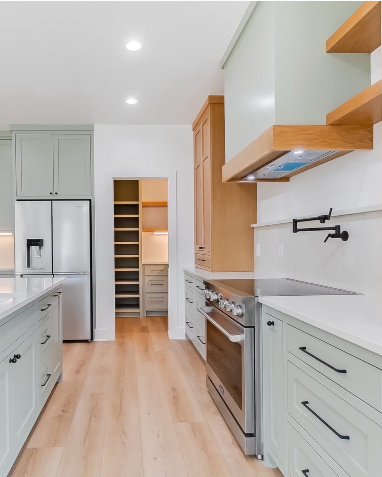 Sage green kitchen with walk-in pantry and open wood shelving — St. Louis remodel by Phoenix Construction Group