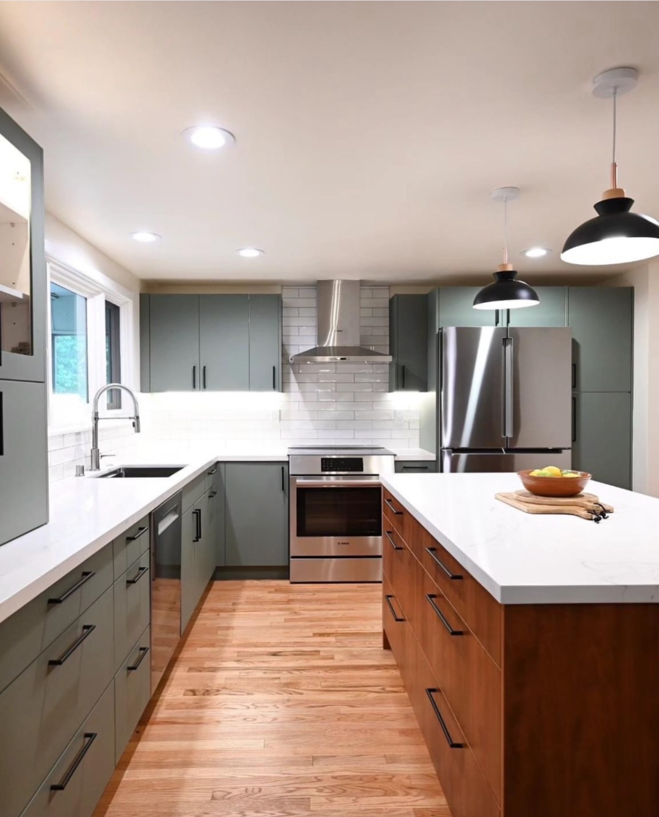 Sage green kitchen with island and hardwood floors — St. Louis remodel by Phoenix Construction Group