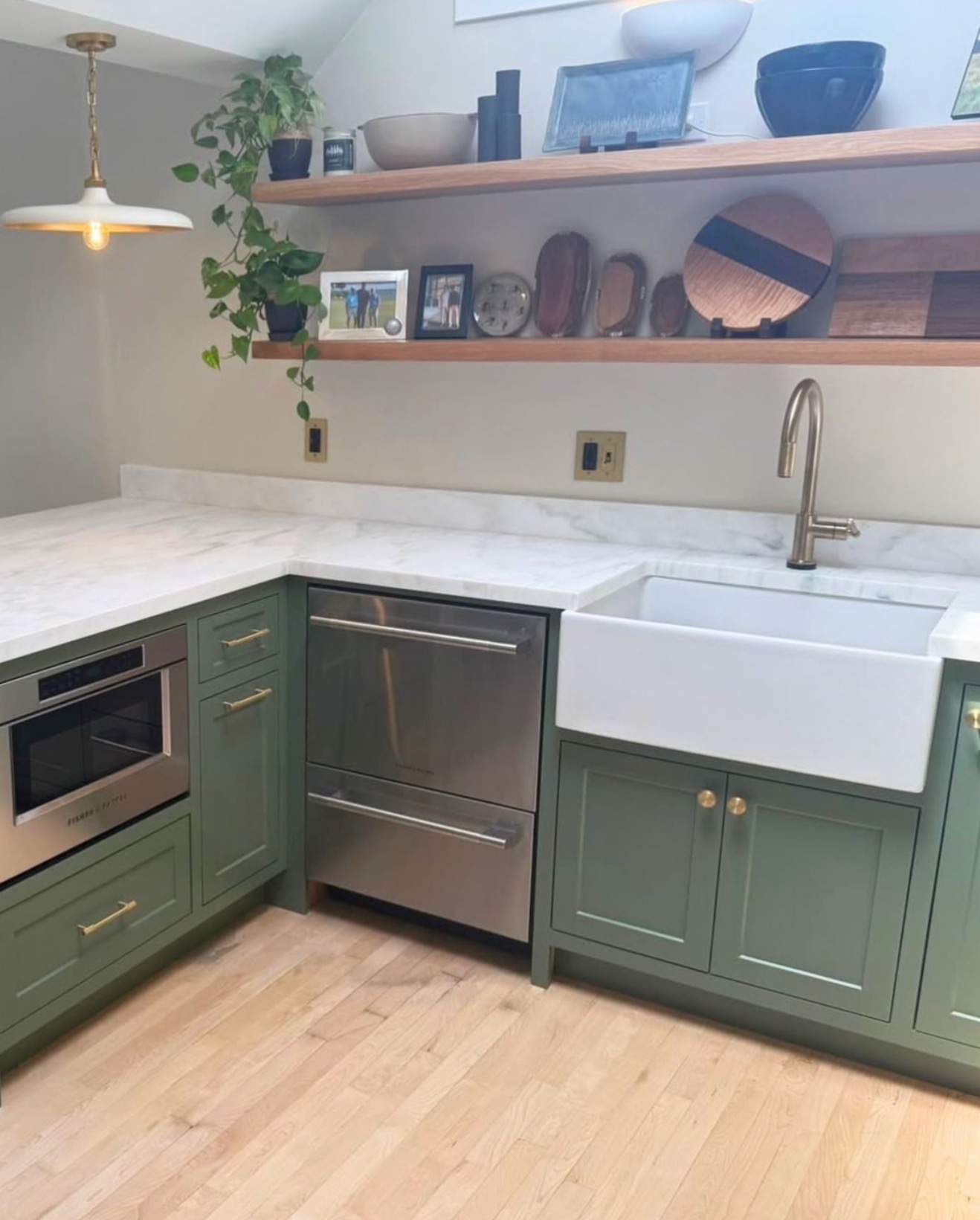 Sage green farmhouse kitchen with apron-front sink — St. Louis remodel by Phoenix Construction Group
