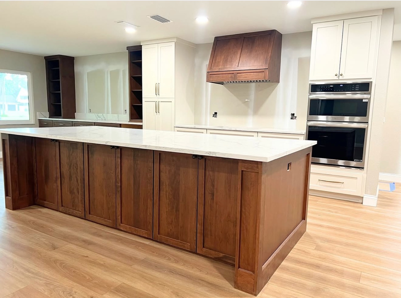 Warm cherry wood kitchen with large island and white countertops — St. Louis remodel by Phoenix Construction Group